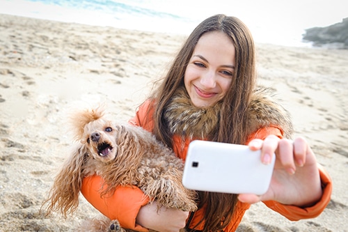 Woman taking a selfie with her dog who is trying to escape