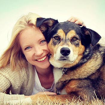 woman laying in the grass with dog
