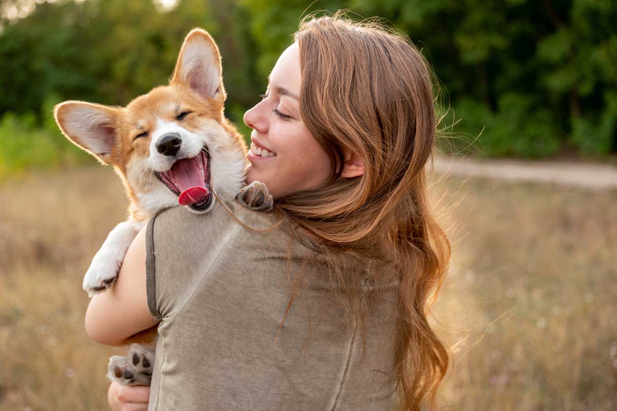 woman holding happy corgie